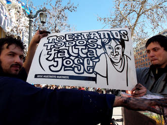 Miembros del Colectivo Serigrafía Instantánea imprimiendo un afiche sobre José Huenante en la Alameda