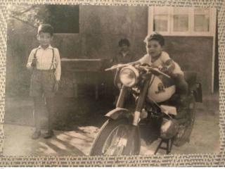 Luis Guajardo en su infancia junto a un niño sobre una motocicleta