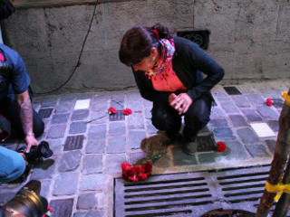 Susana Zúñiga pone flores en la placa que recuerda a su padre, Eduardo Zúñiga.